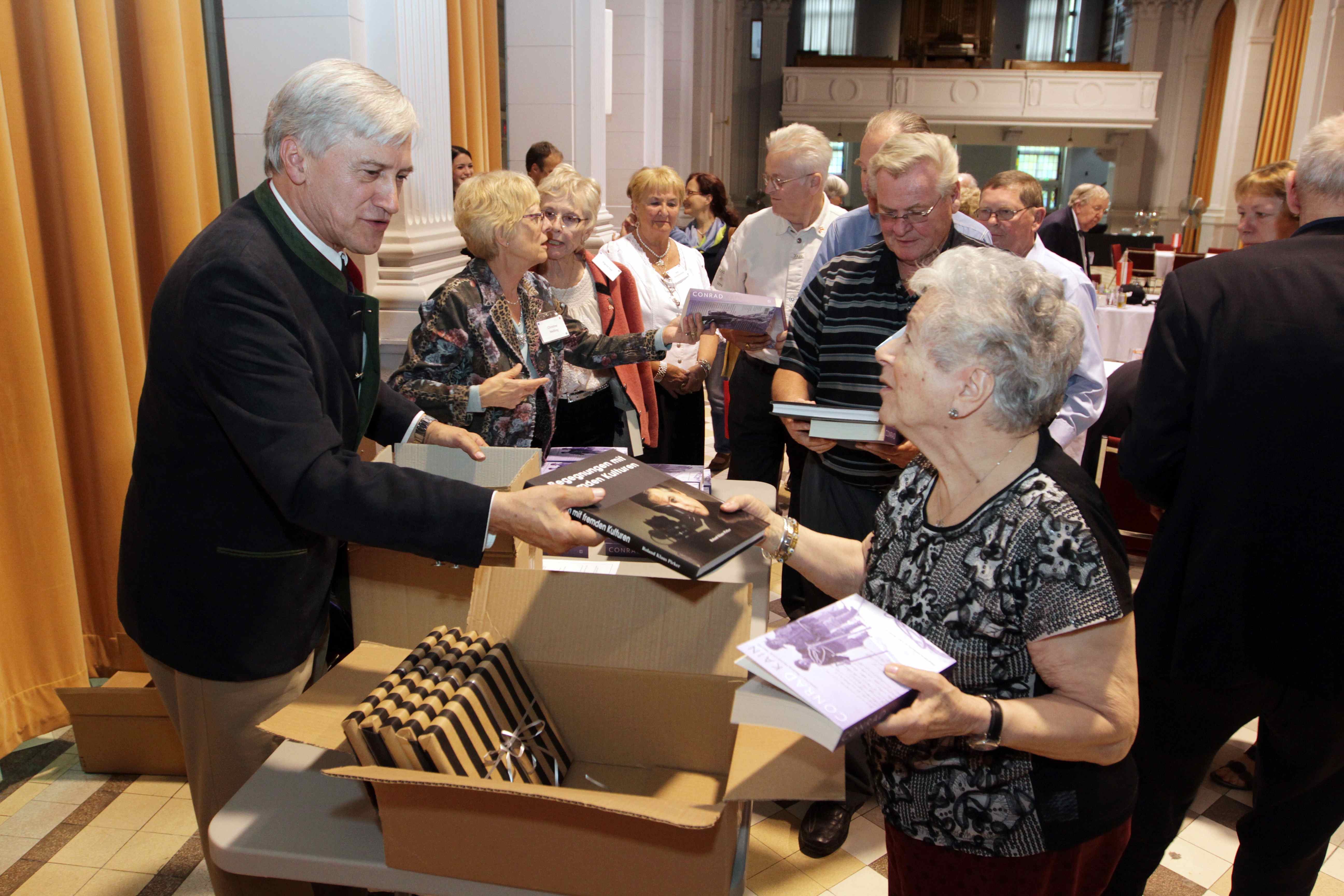 Roland Pirker and Christine Welling distribute copies of books by Conrad Kain and Roland Pirker